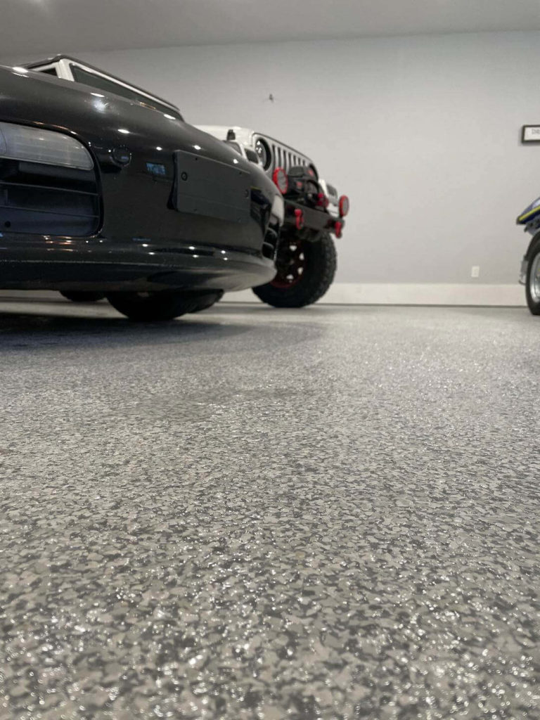 Photo of garage floor with the bumper of a car in the corner